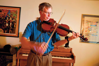 Bill Krzymowski, a physician at the Gallup Indian Medical Center, plays his viola at his home Tuesday. Krzymowskji hs been invited to play with an international orchestra of physicians at a 9/11 memorial concert in the Washington area on Sunday. &copy; 2011 Gallup Independent / Brian Leddy 